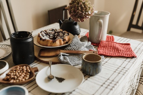 A table in a kitchen filled with seasonal food and various linens you can use to update your kitchen design this fall. 