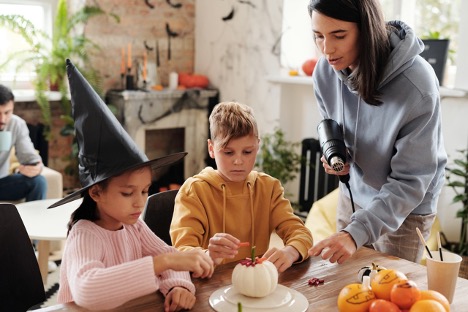 A woman helping her kids with DIY decor.