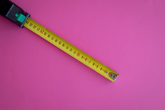 Yellow measuring tape on a pink background for custom storage solutions