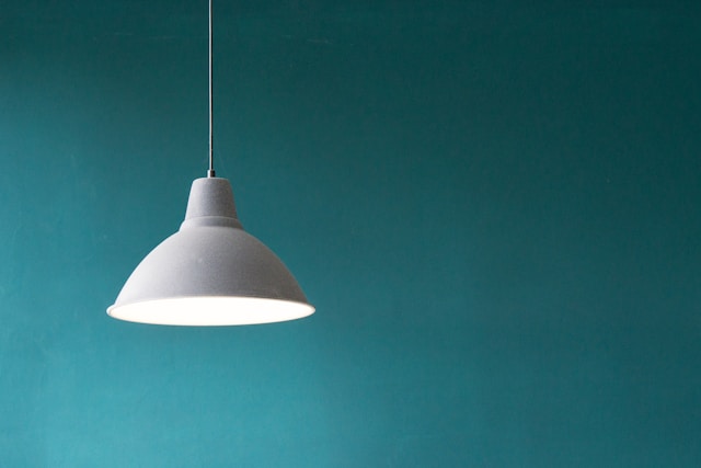 White lamp hanging from the ceiling, green background.