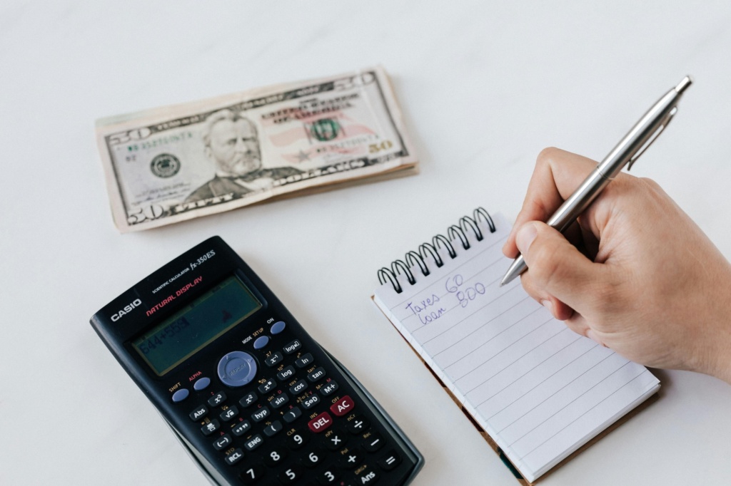 Calculator, notebook and money on a table