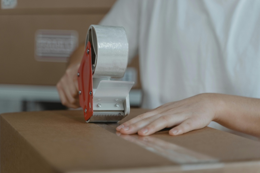 A person putting tape on a box